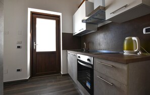 A kitchen with a wooden door, stainless steel appliances, and a kettle on the counter. - 1 bedroom amazing apartment in Palermo (Palermo)