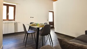 Un comedor con una mesa, sillas y un ventanal.