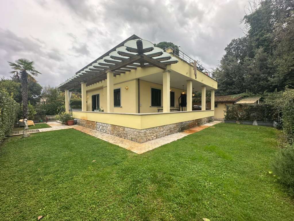 Une maison de plain-pied dotée d’un patio couvert, de fondations en pierre et d’une pelouse bien entretenue.