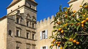 Un edifici històric amb una torre, finestres d'arc i un balcó.