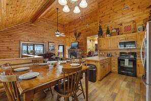L'intérieur d'une cabane en bois comprend un coin repas, une cuisine et un espace de vie.