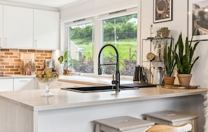 A kitchen with a large window, a sink, and various kitchen items. - Awesome apartment in Strandebarm (Strandebarm)