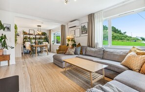 A modern living room with a sofa, coffee table, and dining area.