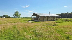 Een laag gebouw met schuine kap, een veranda en schoorsteen.