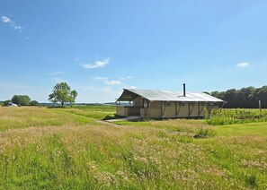 Een laag gebouw met schuine kap, een veranda en schoorsteen.