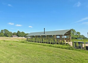 A single-story building with a flat roof, a chimney, and a covered porch area.