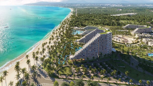 A resort with a beach, palm trees, and a large building with multiple balconies. - Căn hộ The Oceanfront tại Cam Ranh (The Oceanfront Apartment At Cam Ranh) (Cam Lâm)