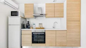 Une cuisine moderne équipée d’un four encastré, d’un four à micro-ondes et d’une machine à café posée sur le plan de travail.