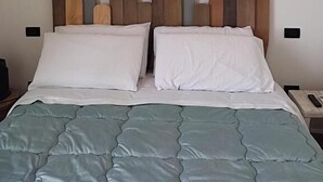 A bed with a headboard, two pillows, and a blue quilt. - VENTO DI BOLINA (Giovinazzo)
