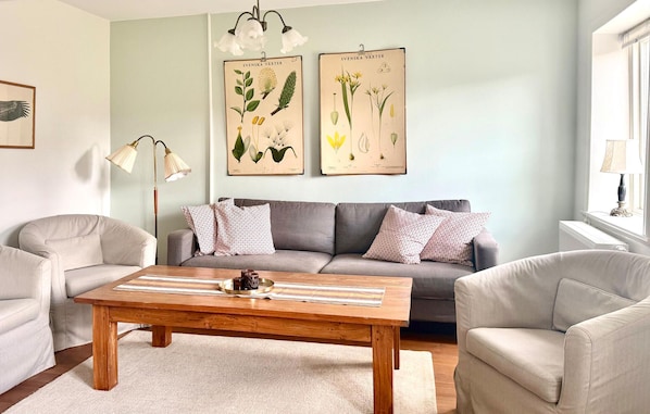 A living room with a sofa, two armchairs, a coffee table, and botanical wall art. - 2 bedroom lovely home in Sjöbo (Sjöbo)