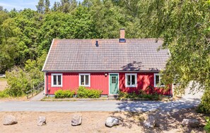 A red house with a tiled roof, a green door, and a chimney. - 2 bedroom lovely home in Sjöbo (Sjöbo)