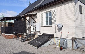 Una casa amb un petit porxo, una rampa i una porta de garatge.