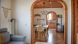 En ombonad inredning med en matplats, trämöbler och ett synligt kök i bakgrunden.