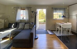 A compact living space with a sofa, a dining table, and a door leading to an outdoor area. - 1 bedroom cozy home in Färjestaden (Färjestaden)