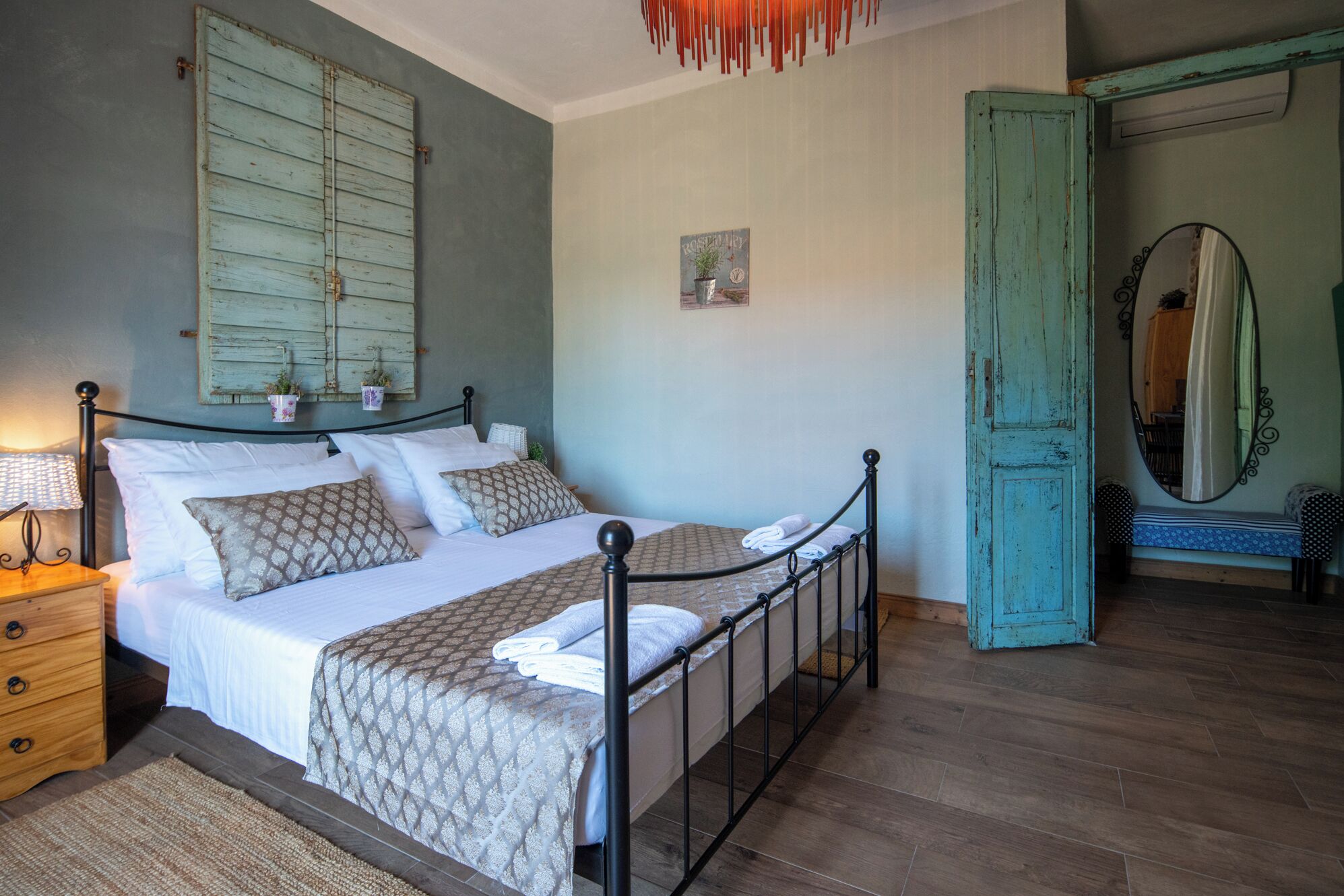 A bedroom with a bed, a dresser, a mirror, and a door.