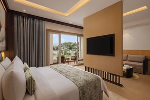 A hotel room with a large bed, a flat-screen TV, a balcony with a view, and a sofa. - Fortune Lakeview Bhimtal – Member ITC Hotels' Group (Nainital)