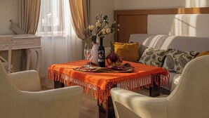 A room with a bed, a desk, a table with a vase, wine, and fruit. - HB apartments Marjani (Tbilisi)