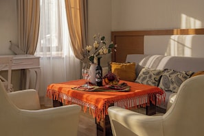 A room with a bed, a desk, a table with a vase, wine, and fruit. - HB apartments Marjani (Tbilisi)
