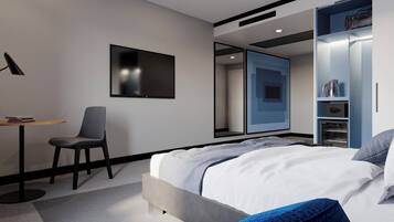 A modern hotel room with a bed, a desk, a chair, a wardrobe, and a mirror.