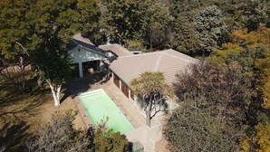 A residential property with a fenced yard, a swimming pool, and a garage. - Room-heron Room - Staynest Guesthouse (Johannesburg)