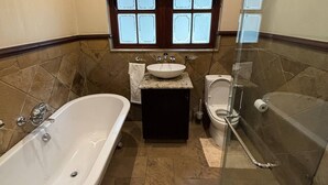 A bathroom with a bathtub, toilet, sink, and shower. - Room-heron Room - Staynest Guesthouse (Johannesburg)