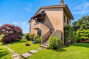 Ein modernes Haus mit einem einzigartigen architektonischen Design, das eine markante Treppe und einen gepflegten Garten zeigt.