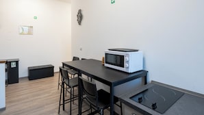 A modern room with a table, chairs, a microwave, a small cabinet, and a map on the wall.
