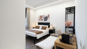 A modern hotel room with a bed, bedside tables, a desk, a mirror, and a wall art piece. -  ReRent Rooms - 36 Trionfale Guesthouse (Rome)
