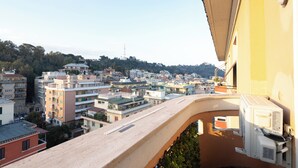 A balcony with a view of a densely packed urban area, buildings, and a distant hill. -  ReRent Rooms - 36 Trionfale Guesthouse (Rome)