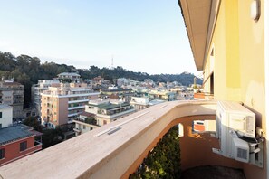 A balcony with a view of a densely packed urban area, buildings, and a distant hill. -  ReRent Rooms - 36 Trionfale Guesthouse (Rome)