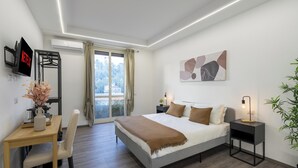 A modern bedroom with a bed, bedside tables, a desk, and a chair. -  ReRent Rooms - 36 Trionfale Guesthouse (Rome)