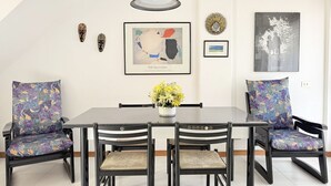 A dining area with a table, chairs, a pendant light, and wall art. - SE249 – Montemarciano, spacious three-room apartment near the sea (Montemarciano)
