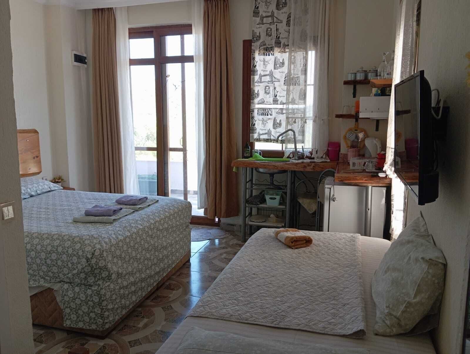 Habitación triple Deluxe, vista al jardín | Cocineta privada | Tetera eléctrica 