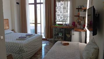 Habitación triple Deluxe, vista al jardín | Cocineta privada | Tetera eléctrica
