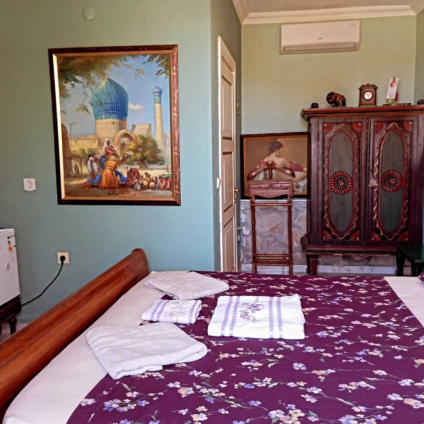 Un dormitorio con cama, un cuadro, un armario y un reloj.