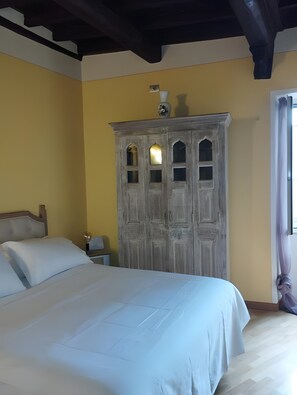 Un dormitorio con una cama, un armario de madera y una mesita de noche.