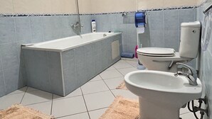 Un baño con bañera, inodoro, lavabo y ducha.