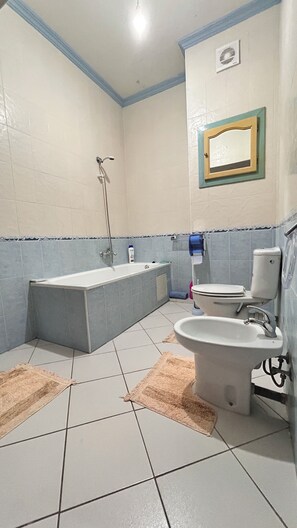 Ein Badezimmer mit Badewanne, Toilette, Waschbecken und Dusche.