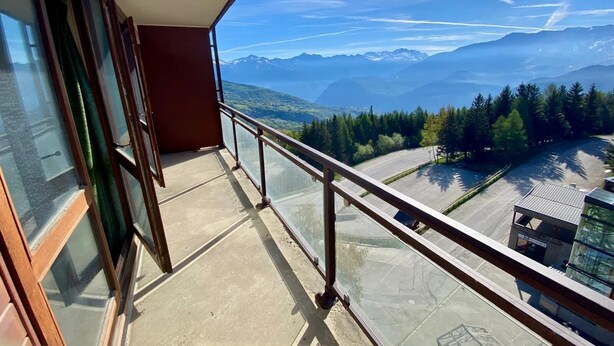 Un balcone con vista libera su montagne e una strada.