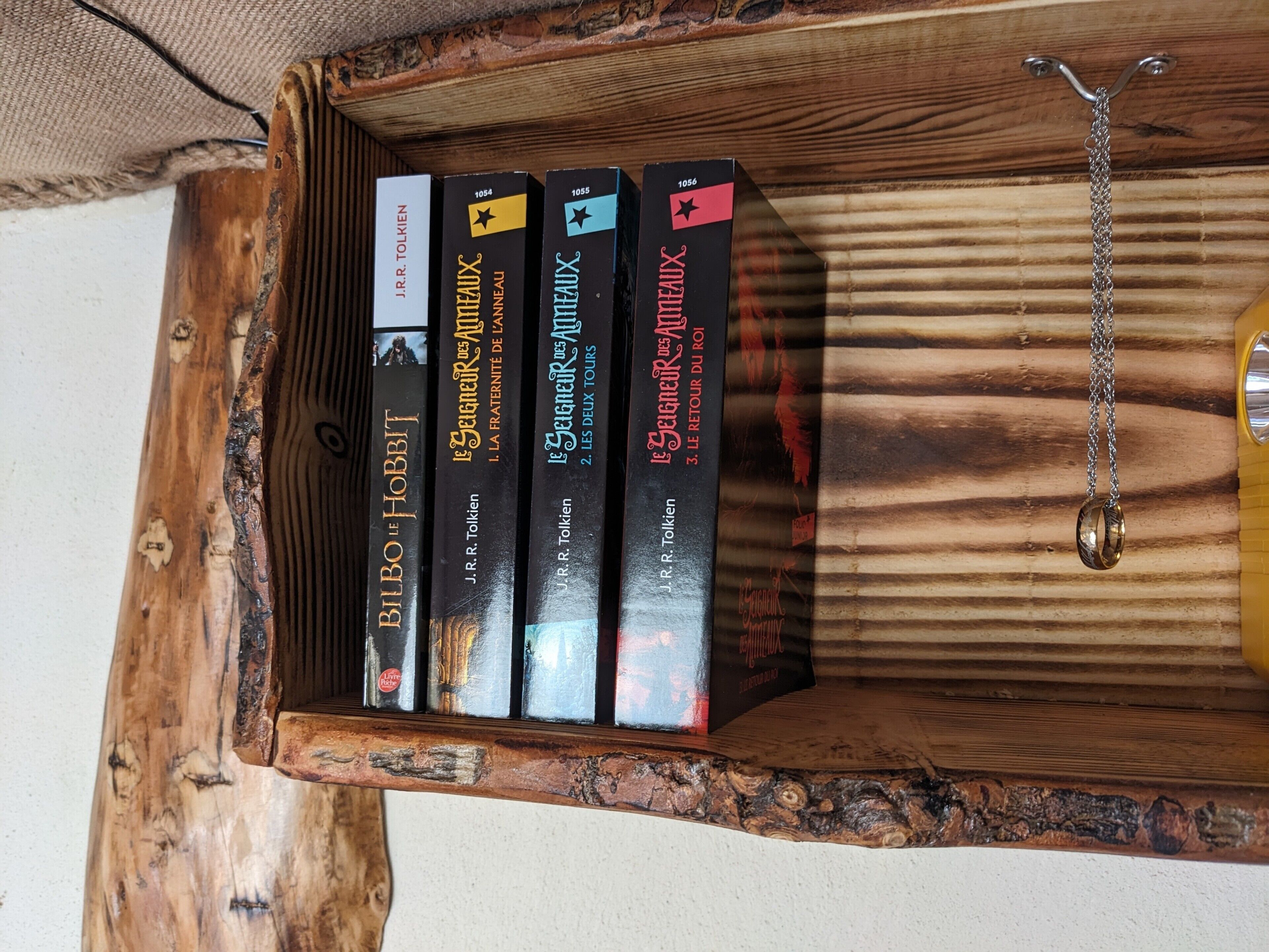 A wooden box containing books with visible text, including titles and author names.