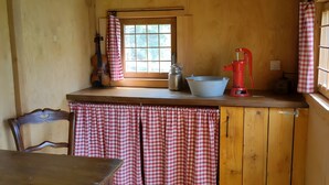 A kitchen with a wooden counter, a red and white checkered cloth, a kettle, a blue bowl, and a red appliance. - Tiny House “La Petite Maison Dans La Prairie” – Nature Retreat Inspired by Your Favorite Series (Lafarre)
