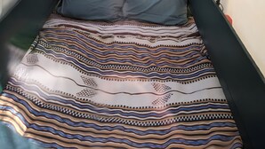 Tienda de campaña con una cama en su interior, que incluye una colcha estampada y almohadas.