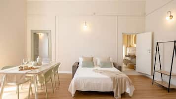 Ein Schlafzimmer mit Bett, Nachttisch und Blick ins Badezimmer.