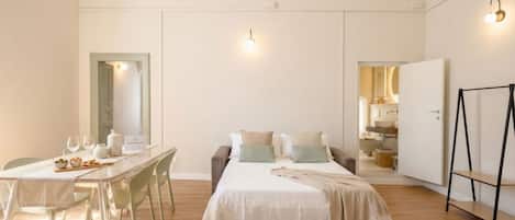 A bedroom with a bed, bedside table, and a view into the bathroom.