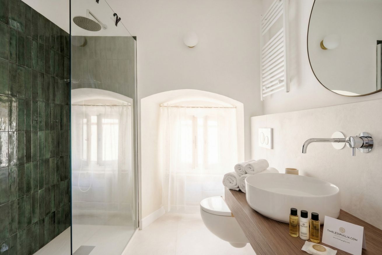 Een moderne badkamer met een douchecabine van glas, een wit wastafelmeubel en een grote spiegel.