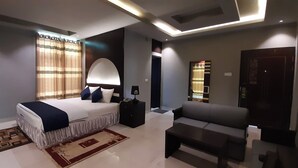Un dormitorio moderno con cama, mesita de noche, lámpara, sofá y alfombra.