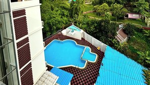 Una piscina en la azotea con vistas a un paisaje verde exuberante y un templo a lo lejos.