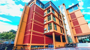 Un edificio de varios pisos con un suelo de patrón a cuadros, una fachada destacada de ladrillo rojo y una entrada de vidrio.