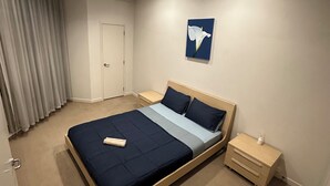 Un dormitorio con cama, mesitas de noche, aire acondicionado de pared y un cuadro.