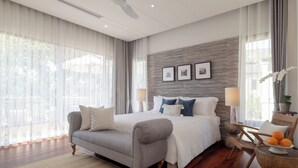 A bedroom with a bed, a sofa, a chair, a lamp, and a side table with fruit. - Serene Maerim Villa (Mae Rim)